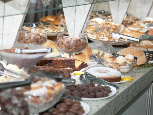 een tafel vol verschillende soorten gebak en desserts bij Ody Park Resort Hotel in Iguaraçu