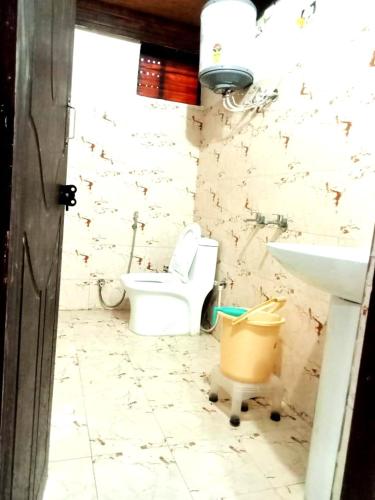 a bathroom with a toilet and a sink at Hotel Radha Krishana in Māna