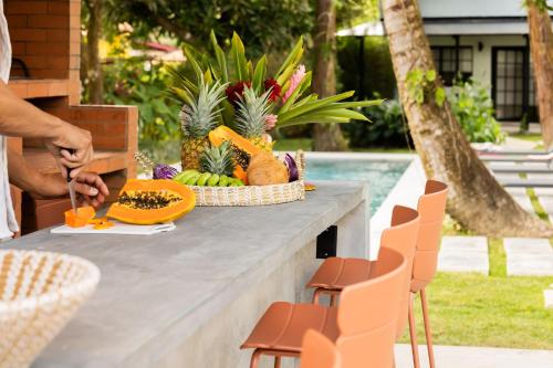 a table with a bowl of fruit and a bowl of pineapple at Altavida Lodge Brand New Studio with Pool in El Valle in Valle de Anton