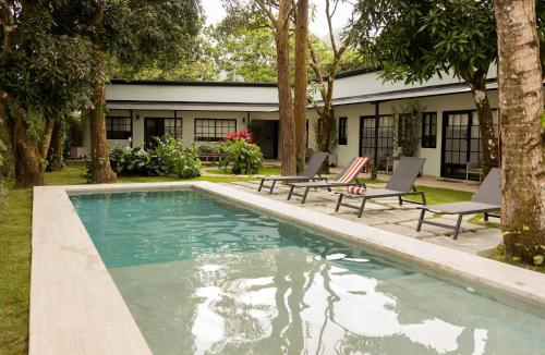 a swimming pool with two chairs and a house at Altavida Lodge Brand New Studio with Pool in El Valle in Valle de Anton