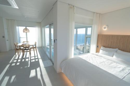 a bedroom with a bed and a table and chairs at 대천 아이오션 풀빌라 호텔 in Koryŏng