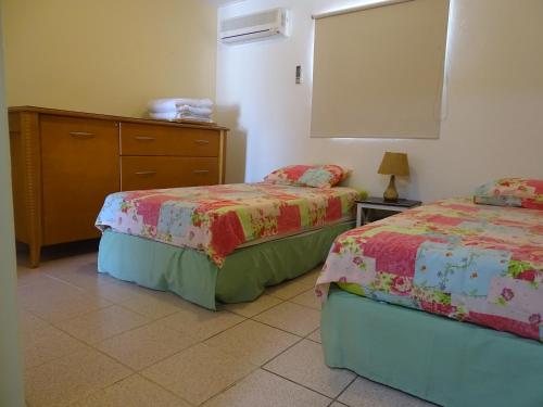 a bedroom with two beds and a dresser at Hacienda Wayaca Apartments in Wayaca