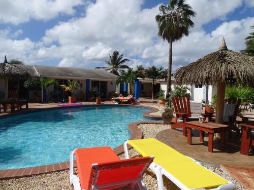 a swimming pool with chairs and a table at Hacienda Wayaca Apartments in Wayaca