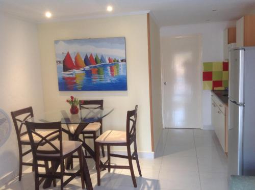 a dining room and kitchen with a table and chairs at Hacienda Wayaca Apartments in Wayaca