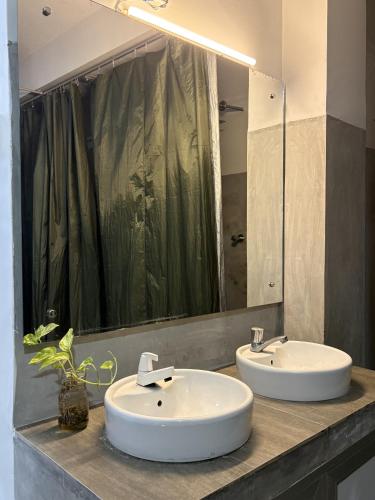 a bathroom with two sinks and a large mirror at Beach Break Surf Hostel in Weligama