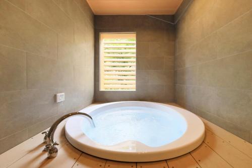 a large bath tub in a bathroom with a window at ゆるり箱根withDOGS in Hakone