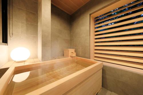 a bath tub in a bathroom with a window at ゆるり箱根withDOGS in Hakone