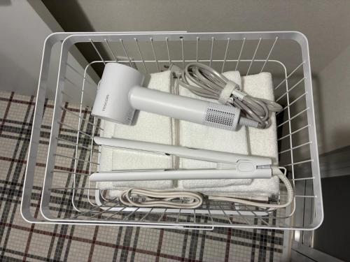a wire basket with towels and a hair dryer at trive osu monzencho 601 最大5名宿泊可能 大須商店街徒歩スグ in Nagoya