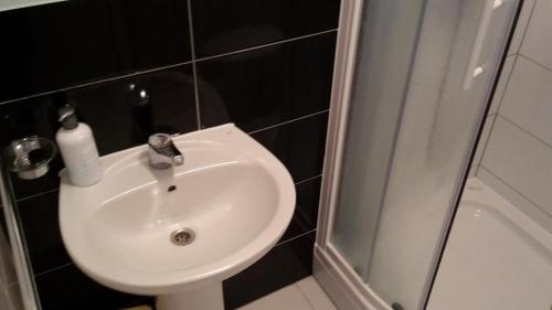 a white sink in a bathroom with a shower at Hotel ''Marinko Kozina'' - Medjugorje in Međugorje