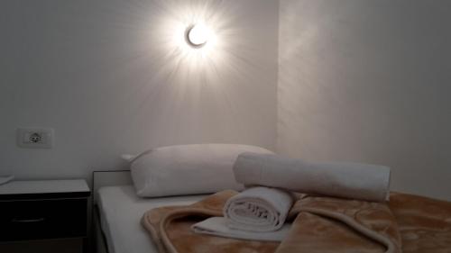a bed with towels and a light on the wall at Hotel ''Marinko Kozina'' - Medjugorje in Međugorje