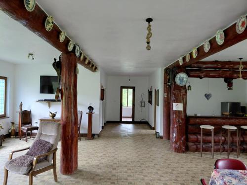 a living room with a staircase and some chairs at Cabana Țibleș Bichigiu in Bichigiu