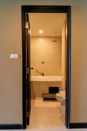 a bathroom with a toilet and a bath tub at Royal Phala Cliff Beach Resort in Ban Chang