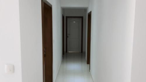 a hallway with white walls and wooden doors at Hotel ''Marinko Kozina'' - Medjugorje in Međugorje