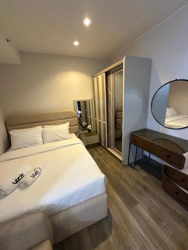 a bedroom with a large bed and a mirror at Fully Furnished Hotel Studio for Rent in ZED Towers Sheikh Zayed in Sheikh Zayed