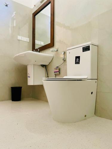 a bathroom with a sink and a white refrigerator at Ayubowan Yala in Tissamaharama