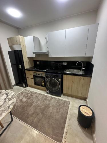a small kitchen with a sink and a stove at Fully Furnished Hotel Studio for Rent in ZED Towers Sheikh Zayed in Sheikh Zayed