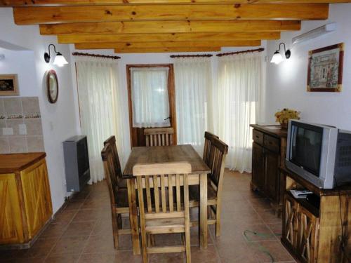 uma sala de jantar com uma mesa e uma televisão em Cabañas Rukayen em Villa La Angostura