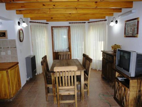 a dining room with a table and a television at Cabañas Rukayen in Villa La Angostura