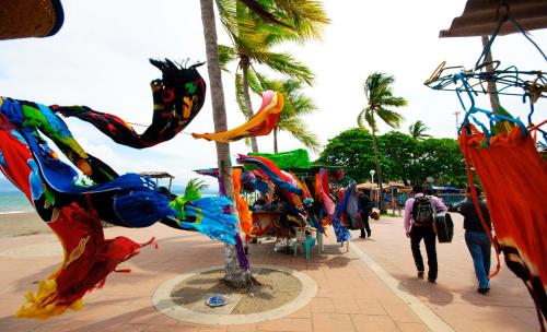 a group of colorful statues on a sidewalk near the beach at Hotel Puntarenas Beach in Puntarenas