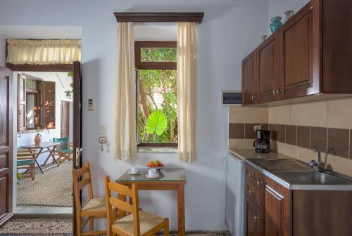 a kitchen with a sink and a table and a window at Erato Apartments in Líndos