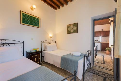 a bedroom with two beds and a kitchen at Erato Apartments in Líndos