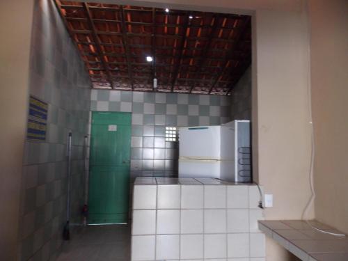 a kitchen with a refrigerator and a green door at Chalés Pontal da Ilha in Itamaracá