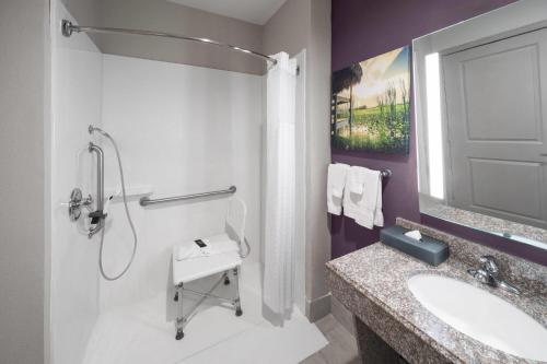 a white bathroom with a sink and a shower at La Quinta by Wyndham Boutte in Boutte