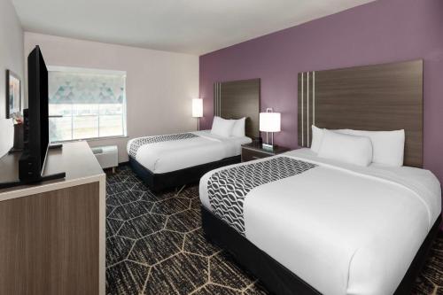 a hotel room with two beds and a flat screen tv at La Quinta by Wyndham Boutte in Boutte