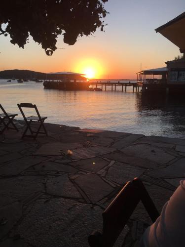 a sunset over a body of water with a pier at Villa Ferradura Mar in Búzios