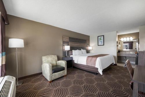 a hotel room with a bed and a chair at Quality Inn Concord Kannapolis in Concord