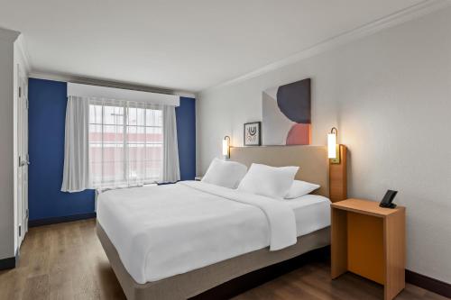 a bedroom with a large white bed and a window at Spark by Hilton Cincinnati Fairfield in Forest Park