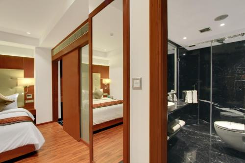 a hotel room with a bathroom with a tub and a sink at Lavender Premier in Bangalore