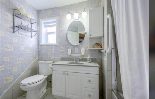 a bathroom with a toilet and a sink and a mirror at Spacious 2 Bedroom Suite in Delta
