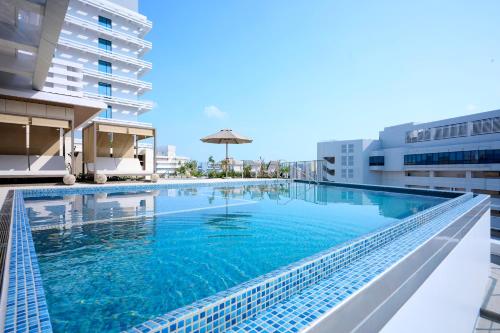 a swimming pool on the roof of a building at The Royal Park Hotel Iconic Naha in Naha