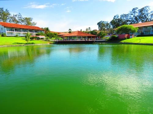 a large green lake in front of a building at Flat Fabuloso 808 Villa Hípica in Gravatá