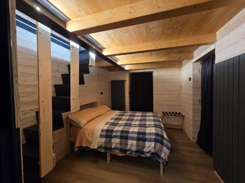 a bedroom with a bed in a wooden cabin at Muranche Lofts N1 in Valtournenche