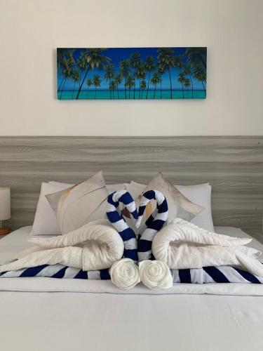 a bed with two towels on it with palm trees at Villa Argento in Rimbudu
