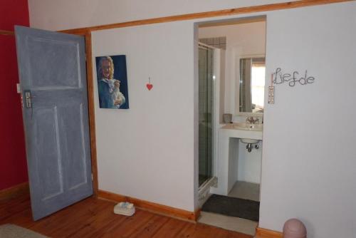 a bathroom with a door leading to a sink at Hannah's Haven in Beaufort West