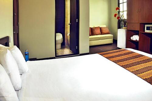 a bedroom with a white bed and a mirror at Hoteles Riviera Mansion in Arequipa