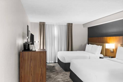 a hotel room with two beds and a television at Country Inn & Suites by Radisson, Winnipeg, MB in Winnipeg