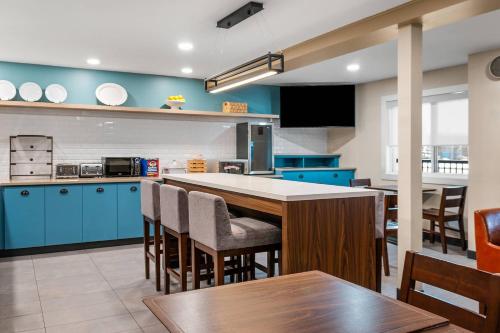 a kitchen with blue cabinets and a table and chairs at Country Inn & Suites by Radisson, Winnipeg, MB in Winnipeg
