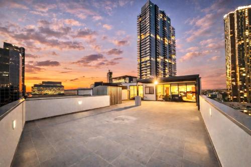 a rooftop deck with a view of a city skyline at Modern Penthouse 7-min Walk to Station & Westfield in Sydney