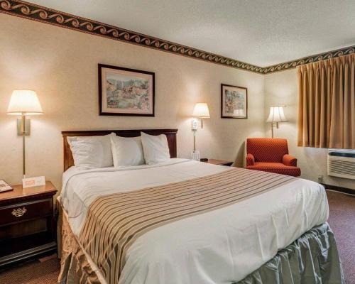 a hotel room with a large bed and a chair at Econo Lodge Inn & Suites El Paso West in El Paso