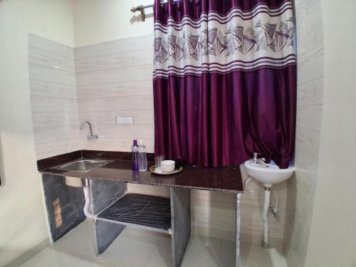 a bathroom with a sink and a red shower curtain at Laxmi Niwas, Salt Lake, Kolkata, 10mins from Sector 5 in Kolkata