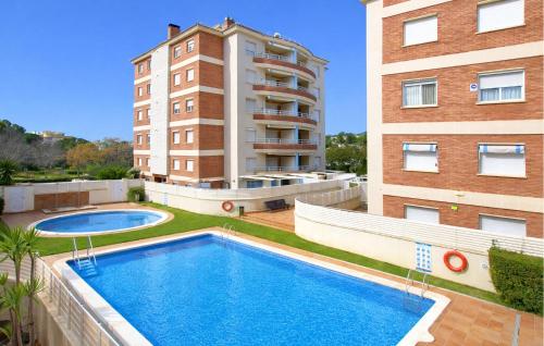 a swimming pool in front of two tall buildings at Gorgeous Apartment In Calafell With Swimming Pool in Calafell
