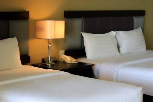 a hotel room with two beds with a lamp and a phone at Royal Phala Cliff Beach Resort in Ban Chang