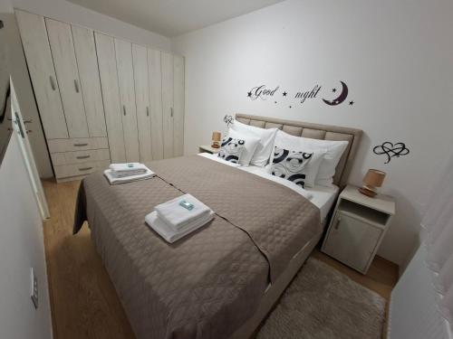 a bedroom with a large bed with aigil at Apartman TRI KRALJA 4 in Banja Koviljača
