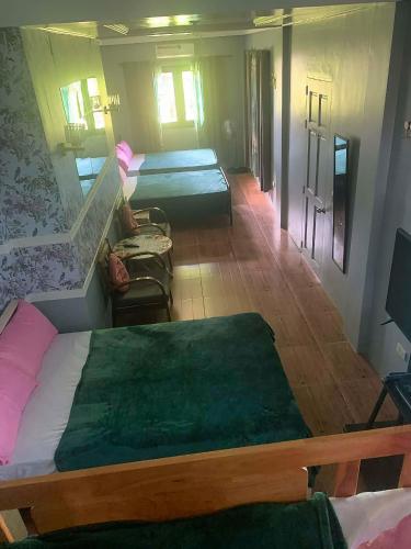 a room with two beds and a living room with at THE OASIS RESORT CondoBimbo 1-Big Room, Balcony, kitchen, Pool, Wifi, Videoke in San Fernando