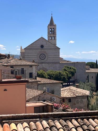 a church with a clock tower and a town with roofs at CharmandView Assisi - vista unica su Basilica di Santa Chiara con terrazza panoramica esclusiva nel centro storico in Assisi