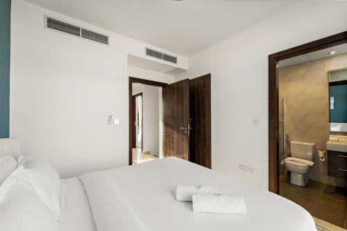 a bedroom with a white bed and a toilet at FIRST CLASS Villa Peaceful Pool View Retreat in Dubai